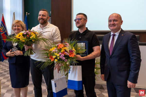 Na zdjęciu znajdują się cztery osoby. Prezydent Miasta Szczecin - Piotr Krzystek oraz nowi ambasadorowie Szczecina. Duet Catz'n'Dogz i Radna Miejska trzymająca bukiet kwiatów.